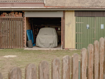 Rear view of woman sitting on wooden house