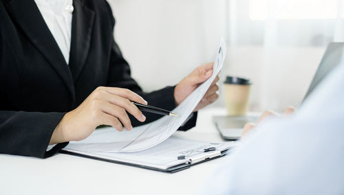 Midsection of businessman working on table