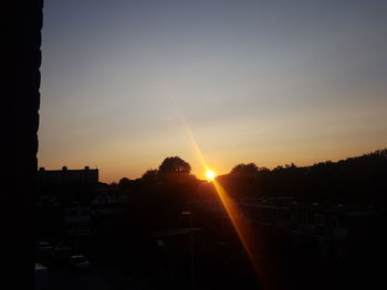 Silhouette city against sky during sunset