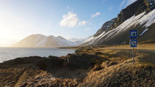 Scenic view of road by mountains against sky