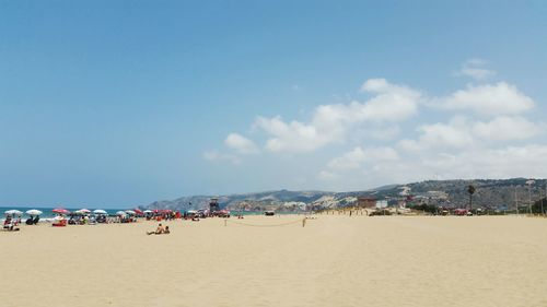 Group of people on beach against sky