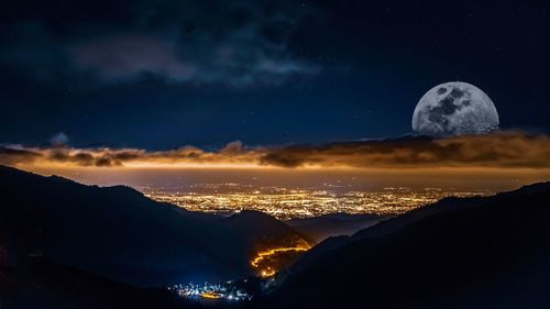 Scenic view of silhouette mountains against sky at night