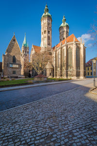 View of street and buildings against blue sky