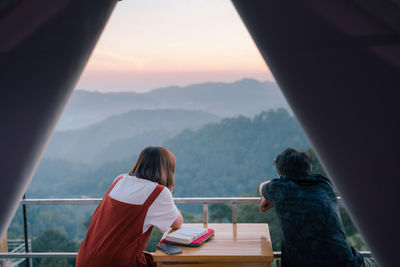 Rear view of people on mountain against sky