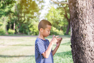 Boy standing on tree trunk