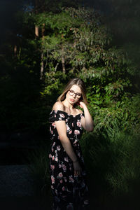 Beautiful woman standing by plants outdoors