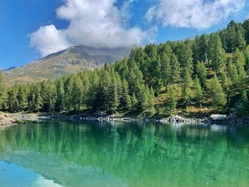 Scenic view of lake by mountains against sky