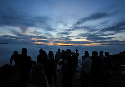 Silhouette people against sky during sunset