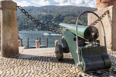 Man standing on metal by sea against sky