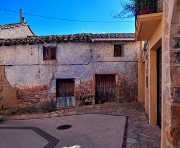 Old building by street against sky