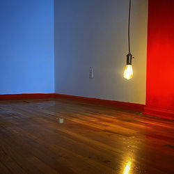 Illuminated lamp on floor against wall at home