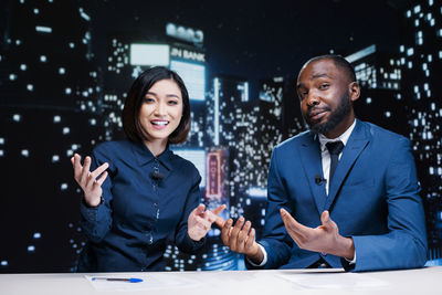 Portrait of young man standing against illuminated lights
