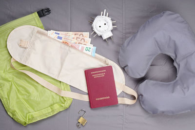 Directly above shot of currency with passport and neck pillow on seat