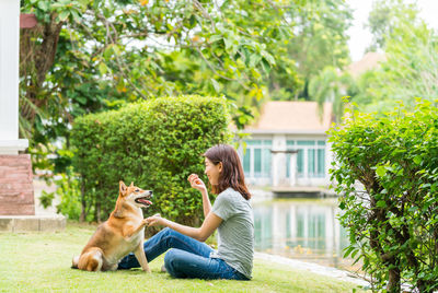 Full length of young woman with shiba dog