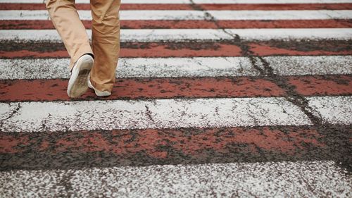 Low section of man walking on street