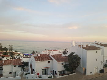 High angle view of townscape by sea against sky