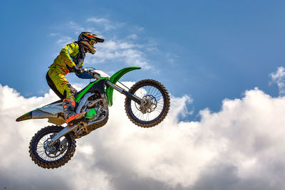 Low angle view of person riding bicycle against sky