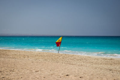 Umbrella on beach against clear sky