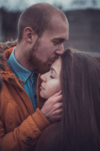 Close-up of couple embracing while standing outdoors