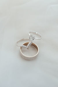 Close-up of wedding rings dainty beautiful wedding heart engagement diamond ring flatlay details