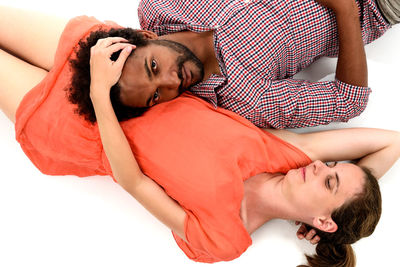 Young woman lying down against white background