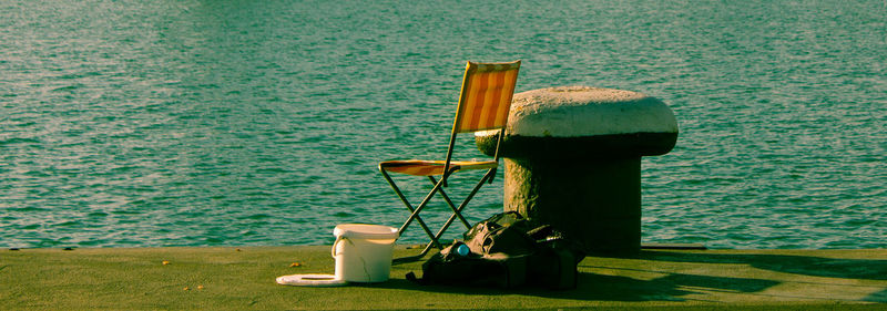 Lamp by sea against grass