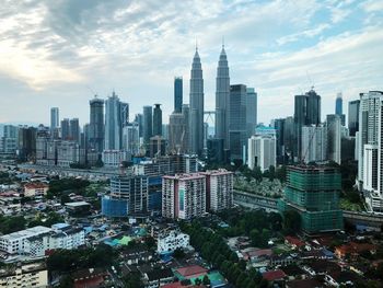 Aerial view of buildings in city against sky