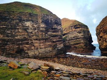 Panoramic view of rocks and sea against sky