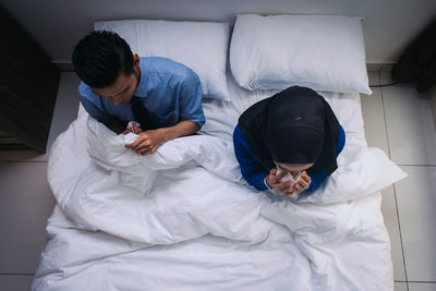 High angle view of friends on bed