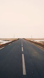 Empty road against cloudy sky