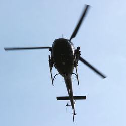Low angle view of helicopter against clear sky