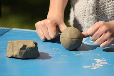 Cropped hands of child playing with clay