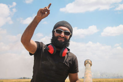 Portrait of man wearing sunglasses standing against sky