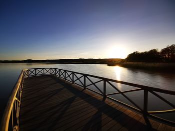 Scenic view of lake against clear sky during sunset