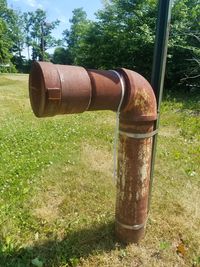 Close-up of rusty pipe on field