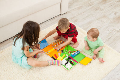 High angle view of children playing with toy on floor