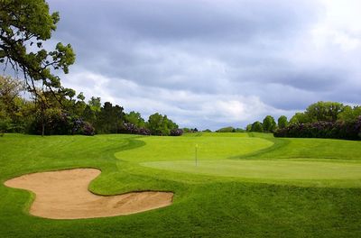 Scenic view of golf course against sky