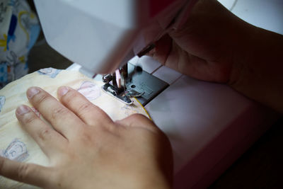 Midsection of person working on sewing machine