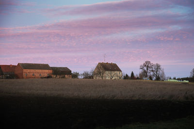 Houses on field against sky