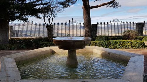 Fountain in city against sky