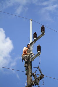 Low angle view of telephone pole against sky