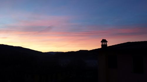 Silhouette house against sky during sunset