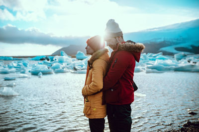 Full length of couple standing in sea during winter