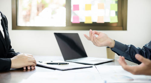 Midsection of businesswoman using laptop at office