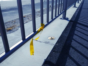 High angle view of yellow railing by sea