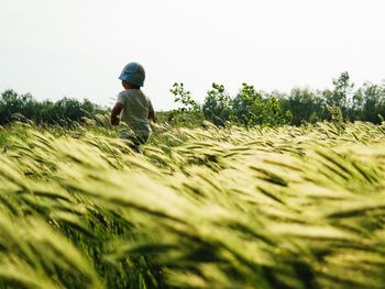 Rear view of woman standing on field