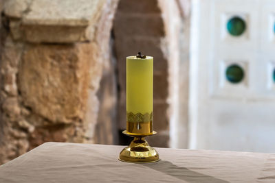 Close-up of bottle on table against wall in building