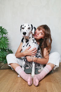 Man with dog sitting on wooden floor