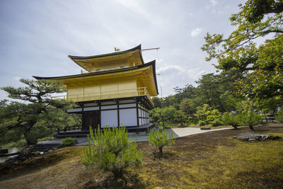 Traditional building by trees against sky