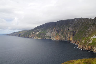 Scenic view of sea and mountains against sky